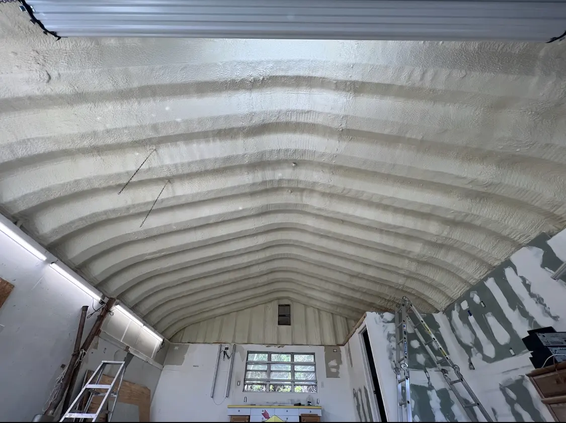 Spray polyurethane foam applied to the underside of a metal roof deck in Plum